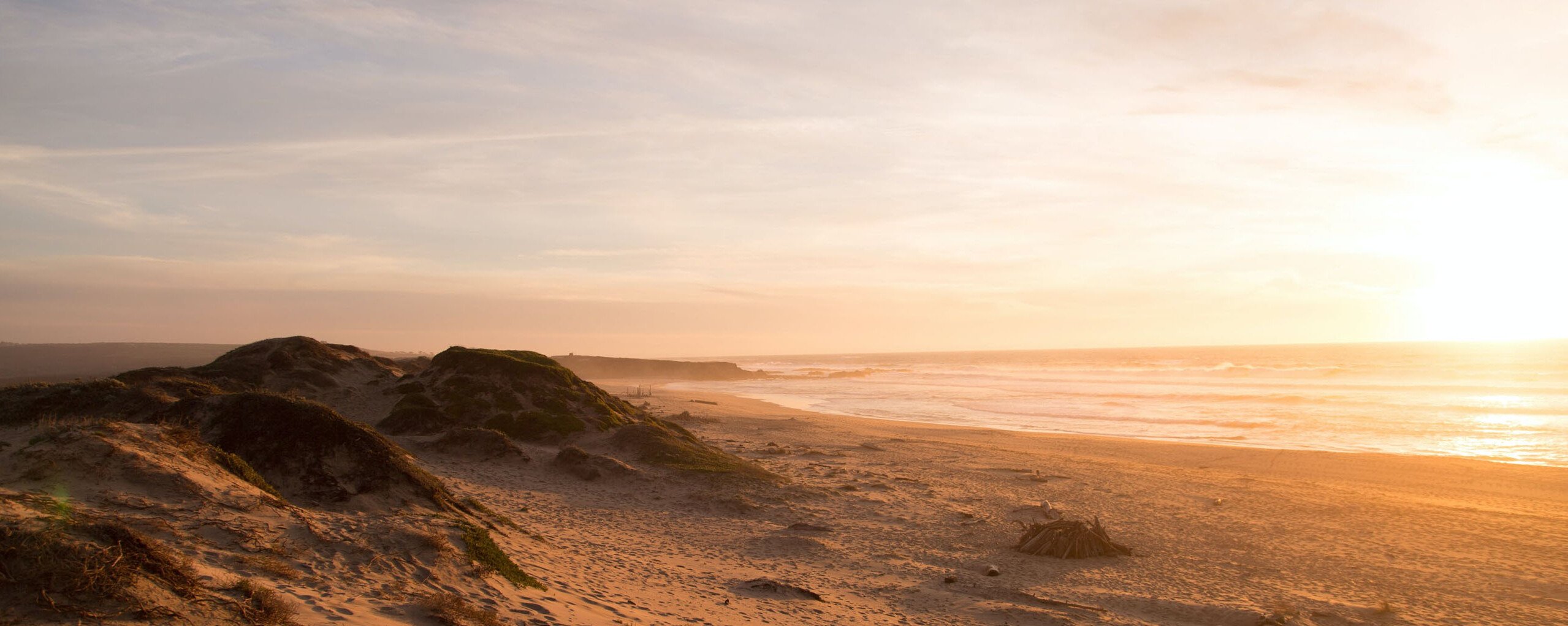 Strand mit Dünen bei Sonnenuntergang